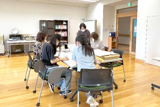 新聞紙で紙スリッパを作成している様子